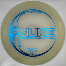 A Discraft Nuke 9000 golf disc in translucent cream with a bright blue foil stamp, shown inside its white retail packaging sleeve.