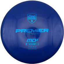 A close-up of a blue disc golf disc on a white surface, featuring the 'discmania' shield logo and 'PREMIER TECHNOLOGY MD3 G-LINE' branding.