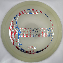 A translucent beige disc golf disc with a patriotic red, white, and blue American flag patterned sticker, featuring the text 'COGARRA' and 'THE STRENGTH OF ONE'.