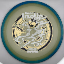 A disc golf disc featuring a metallic gold and silver foil pattern with a skull and smoke graphic, surrounded by a teal outer rim on a white background.