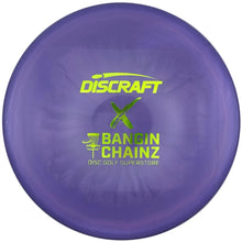 A purple Discraft Bandin Chainz disc golf disc with lime green branding, shown inside its white cardboard packaging.