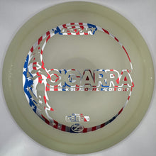 A disc golf disc with a red, white, and blue patriotic foil wrap, displayed inside its white cardboard packaging box.