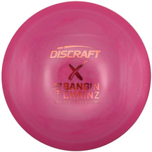 A pink Discraft X Bangin' Chainz disc golf disc resting on a white surface.