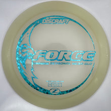 A Discraft Force 2 disc golf disc in translucent cream with a metallic blue foil stamp, shown inside its white protective packaging insert.