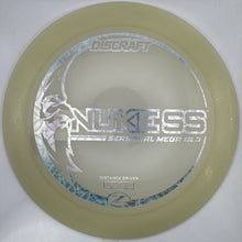 A translucent pale yellow Discraft Nukess seasonal medford distance driver disc golf disc, displayed inside its white cardboard packaging.