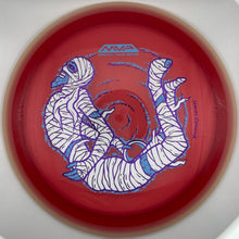 A red disc golf disc with a white and blue mummy graphic and 'MVP' branding, photographed inside a white circular frame.