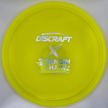 A bright yellow Discraft Bangin' Chainz disc golf disc with white and blue branding, shown inside its white packaging box.