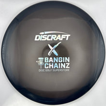 A Discraft disc golf disc with a dark gray translucent flight plate, featuring the white and blue Discraft logo and 'BANGIN' CHAINZ' text, shown inside its white retail packaging.