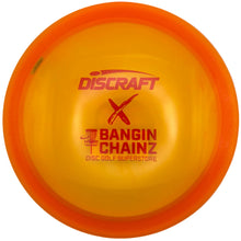 A translucent yellow and orange Discraft disc golf disc with red printed branding, including 'Discraft', 'X', and 'Bangin Chainz Disc Golf Superstore', resting on a white surface.