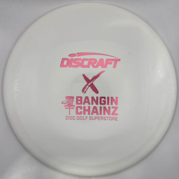 A white Discraft X Bangin' Chainz disc golf disc with pink printed branding, shown inside its white packaging sleeve.