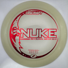 A Discraft Nuke Horizontal Mega Blo disc golf disc in translucent cream with red printed graphics, shown inside its white packaging box.