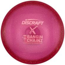 A pink Discraft Bangin' Chainz X disc golf disc with a glittery finish and white printed logo, shown inside its white packaging box.