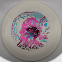 A white disc golf disc featuring a pink and blue graphic of a wolf-like creature holding a pitchfork, with the text 'Coyote Club' and 'Finnian Buckel' printed on it.