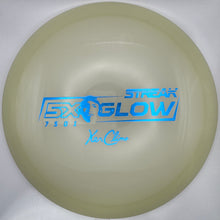 A translucent pale yellow Discraft Stream Glow Fx disc golf disc with blue printed text, shown inside its white packaging box.