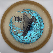 A ProxiOx M5 disc golf disc with a beige base, silver glitter, a gold rim, and a graphic of a harp surrounded by blue waves. The text 'M5', 'PROXIOX', and '53265' are visible on the disc.