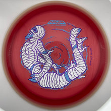 A red disc golf disc with a blue and white graphic of a mummy wrapped in bandages, shown inside a white circular frame.