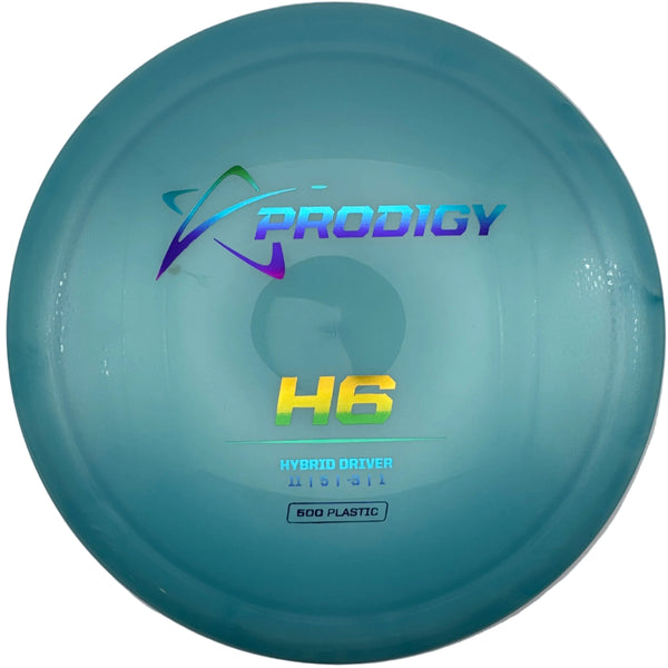 A disc golf disc, specifically a Prodigy H6 hybrid driver, in a white circular presentation box. The disc is a translucent light teal-blue color with the Prodigy logo and 'H6' printed on it.