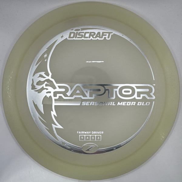 A Discraft Raptor Series 2 Metal God disc golf disc in a translucent pale yellow-green color, resting on its white foam insert packaging.