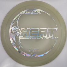A Discraft Heat Seasonal Mega Ball disc golf disc in translucent pale green, shown inside its white plastic sleeve with a purple disc partially visible on the right.