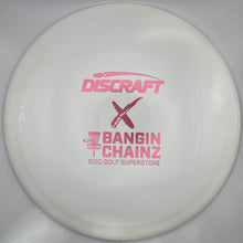 A white Discraft x Bangin' Chainz disc golf disc with pink printed logos, shown inside its white protective packaging sleeve.