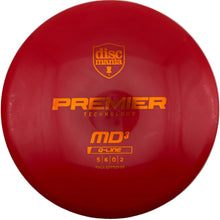 A red Discmania Premier G-Line MD3 golf disc with orange foil stamping, photographed from directly above on a white background.