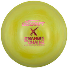 A Discraft Bangin' Chainz X disc golf disc in neon yellow with pink and red printed branding, resting on a white surface.